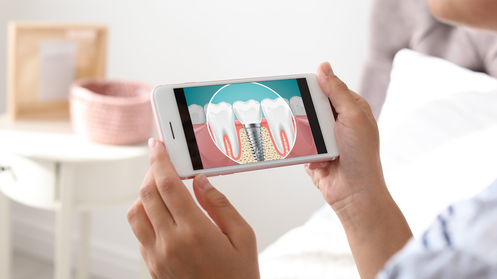 The image shows a person holding a smartphone with an open-mouth illustration on the screen, displaying a visual aid for dental care or oral hygiene.