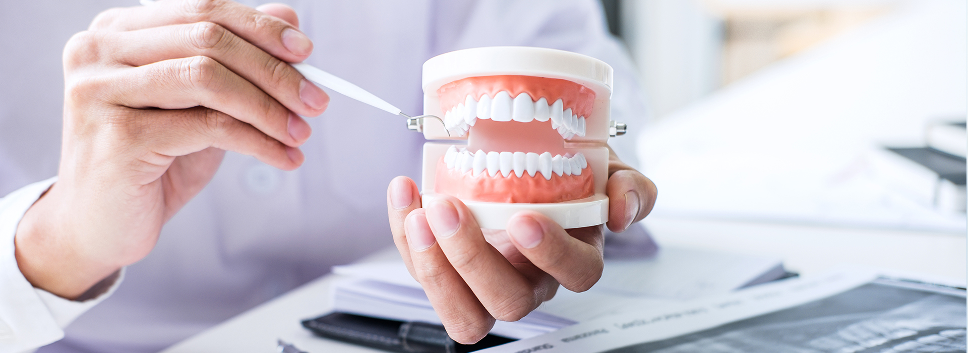 The image shows a person holding a toothbrush and a cup containing dental floss, with a close-up view of a mouth model demonstrating proper brushing technique.