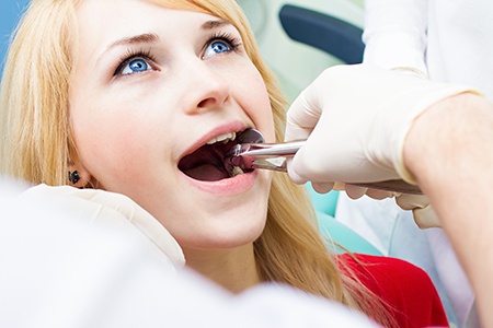 A person receiving dental care with a dental hygienist performing the procedure.